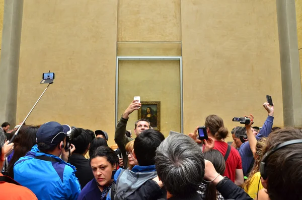 Париж, Франция - 13 мая 2015: Посетителей принять фотографии Leonardo Davinci «Мона Лиза» в музее Лувр Стоковое Изображение