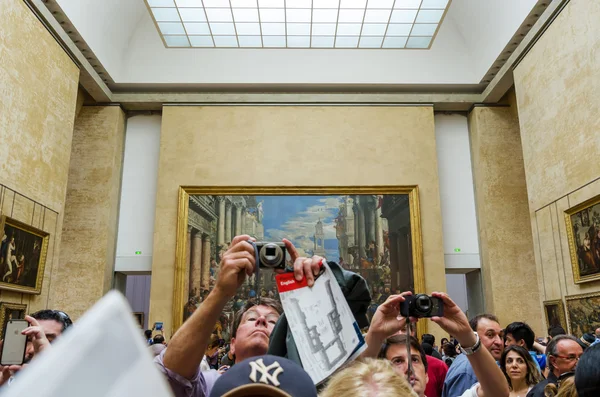 Paris, France - May 13, 2015: Visitors take photos of Leonardo DaVinci's "Mona Lisa" Лицензионные Стоковые Фото