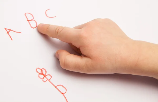 Указательный палец ребенка с буквами — стоковое фото