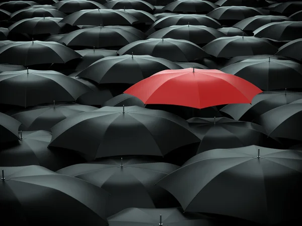 Красный зонт над многими черный зонтики — стоковое фото