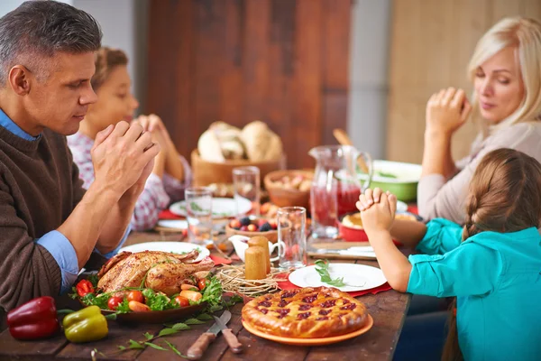 Семья, сидящая за праздничным столом благодарения Лицензионные Стоковые Фото