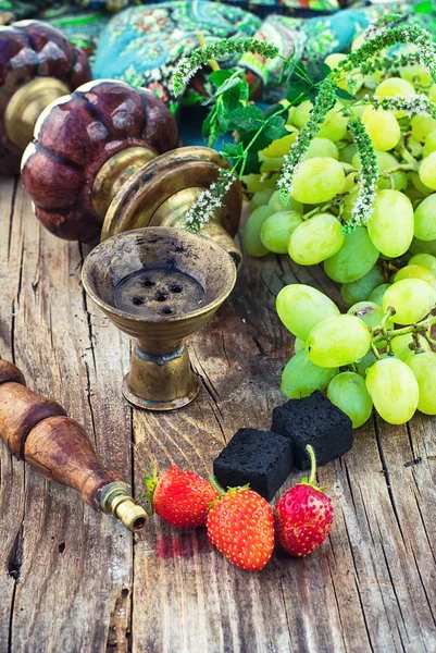 Кальян на фоне гроздья винограда и клубники — стоковое фото