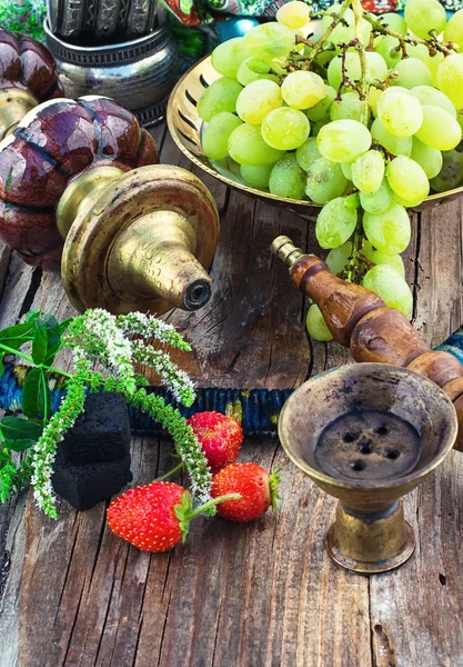 Кальян на фоне гроздья винограда и клубники — стоковое фото