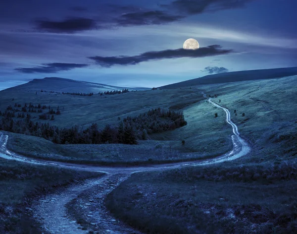 Пересеките дорогу на лугу склона в горе в восходе солнца ночью — стоковое фото