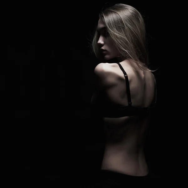 Печаль молодая женщина с голой спиной на черном фоне. темный монохромный портрет сексуальная девушка тела — стоковое фото