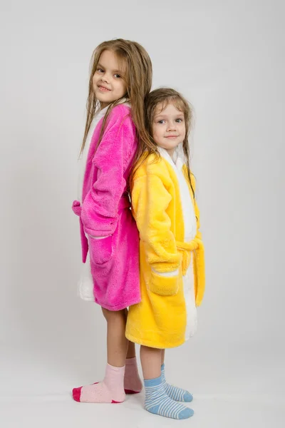 Две девушки в халаты стоят спиной к спине — стоковое фото