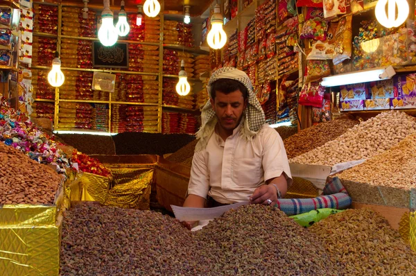 Йеменское человек, сидящих в своем магазине в соли рынок Старого города Саны, Сук, Йемен, продавец, шафран, зерновых, бобовых, кукуруза, орехи, повседневной жизни — стоковое фото