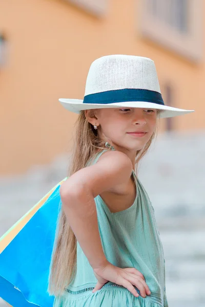 Портрет очаровательны маленькая девочка, ходить с Сумки на открытом воздухе в Риме. Мода малыша малыш в итальянском городе с ее магазинами — стоковое фото