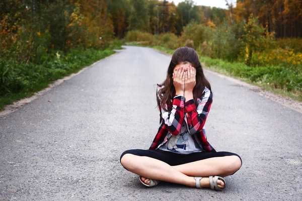 Красивая девушка сесть на пустой дороге страны — стоковое фото