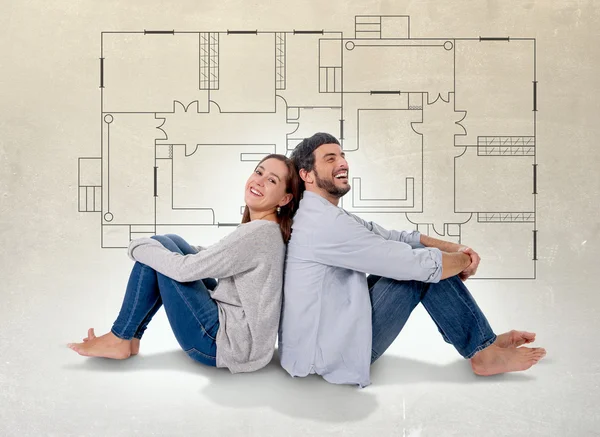Молодая пара, мечтающая и отображение их новый дом в реальном государственном понятии Стоковое Изображение