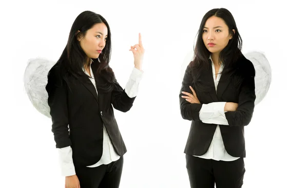 Азиатская молодая деловая женщина нарядила как белый ангел, показывающий непристойный жест другому изолированному на белом фоне Стоковое Изображение