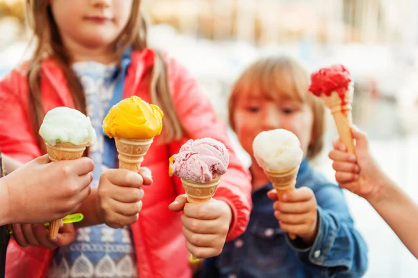 5 corns of colorful ice cream holding by kids Стоковое Изображение