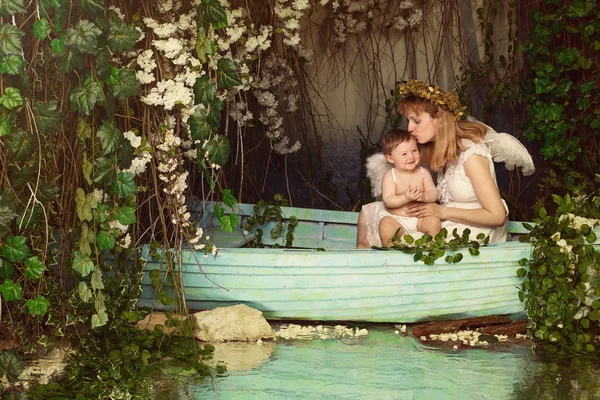 Мать Холдинг и целуя ребенка в лодке — стоковое фото