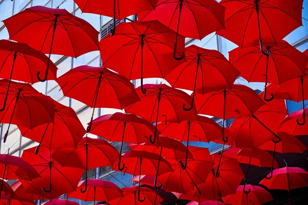 Красные зонты в воздухе — стоковое фото