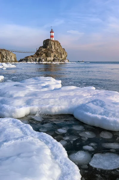 Зимний картинный маяк на одинокой скале. восток (Япония) море Лицензионные Стоковые Фото