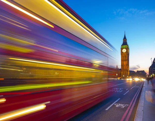Лондон, Великобритания - знаковых красный двухэтажный автобус в движении на синий час с Биг Бен на фоне — стоковое фото
