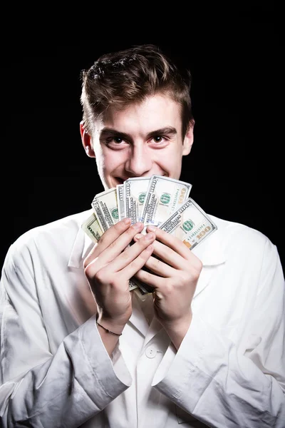 Male medicine cheerful doctor holding in hands euro banknotes.Medic salary, prestige and high paid job.Bribe and corruption concept — стоковое фото