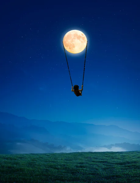 Маленькая девочка на качелях в виде Луны Стоковая Картинка