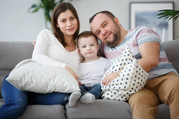 Изображение обнимать семьи с сыном на серый диван — стоковое фото