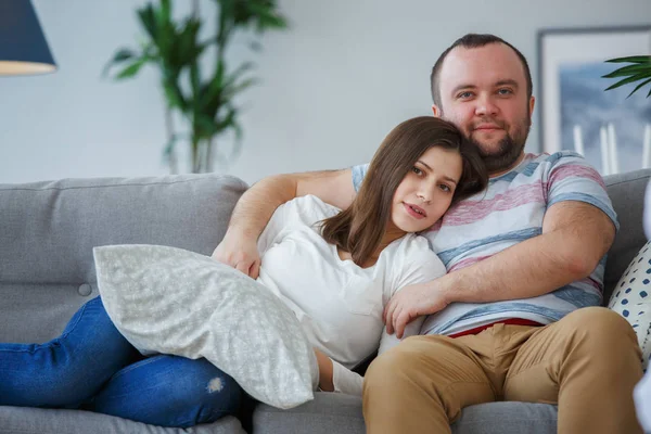 Фото обнимать пару на сером диване — стоковое фото