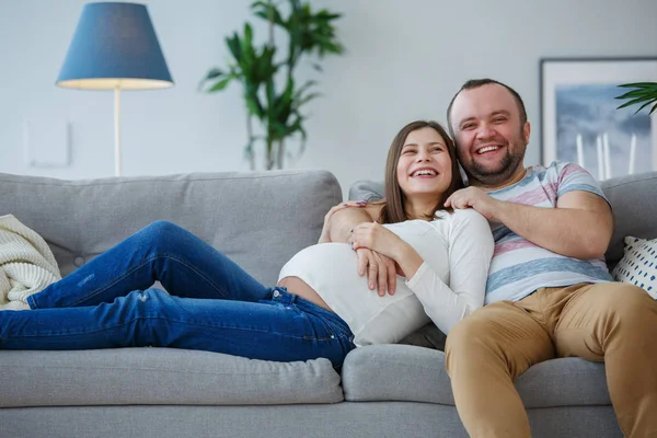 Изображение счастливой беременная женщина и мужчина на сером диване — стоковое фото