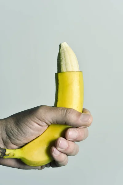 Человек с бананом с кончика его кожи удалены — стоковое фото