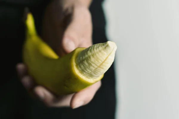 Человек с бананом с кончика его кожи удалены — стоковое фото
