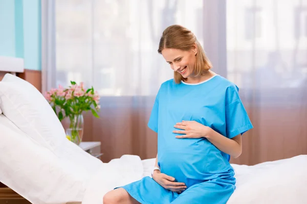 Беременная женщина, касающаяся ее живота — стоковое фото