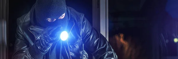 Burglar breaks into house at night — стоковое фото