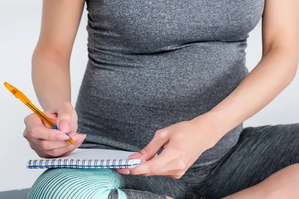 Беременная женщина, писать в блокноте — стоковое фото
