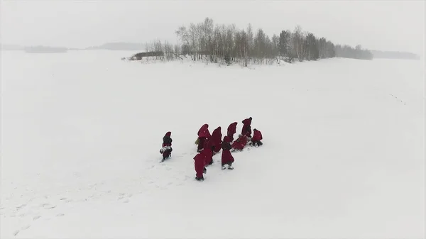 Медитации монахов в лесу в зимний период. Кадры. С капюшоном люди следуют друг за другом в заснеженном лесу как монахи, которые стремятся просветления — стоковое фото