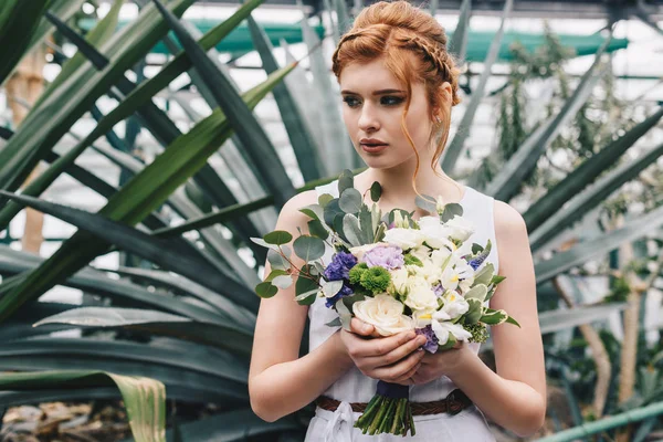 Красивый Рыжий Молодой Невесты Холдинг Свадебный Букет Глядя Ботаническом Саду — стоковое фото