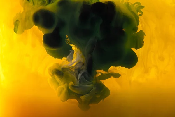 Full Frame Image Mixing Yellow Green Black Inks Splashes Water — стоковое фото