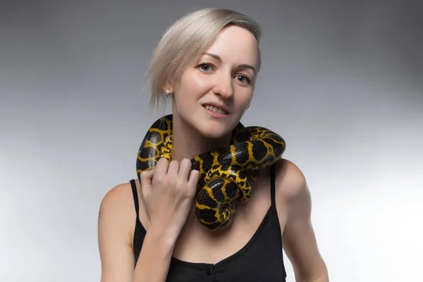 Блондинка женщина и удушения змея — стоковое фото