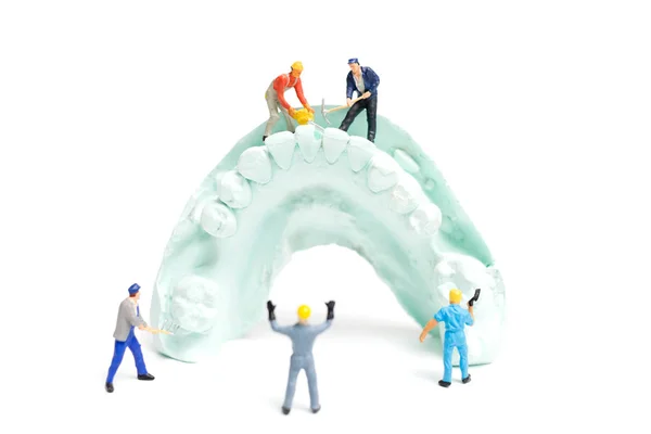 Миниатюрный работник команда подачи поддельных зубы — стоковое фото