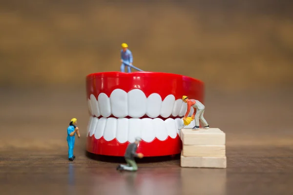 Миниатюрные люди: работник команда восстановление зуба — стоковое фото