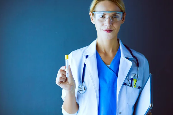 Женский медицинский или научный или доктор, используя глядя на пробирку прозрачный раствор в лаборатории или лаборатории — стоковое фото