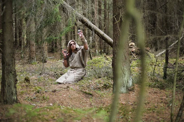 Человек в рясе проводит ритуал в темный лес — стоковое фото