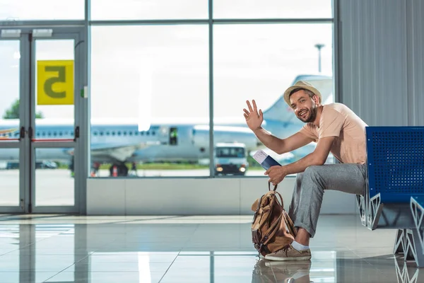Человек, размахивая кому-то в аэропорту — стоковое фото