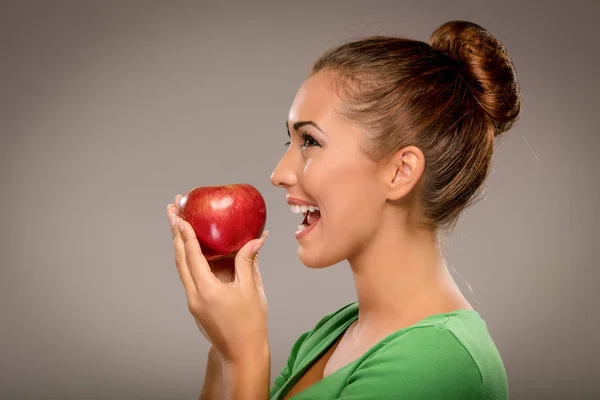 Улыбающиеся женщина кусаться красное яблоко — стоковое фото