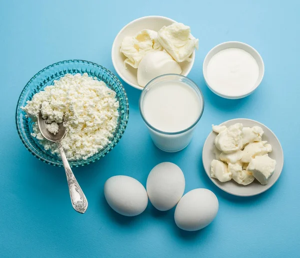 Белковые продукты: сыр, сливки, молоко, яйца на синий му — стоковое фото