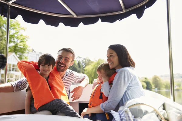 Семья, наслаждаясь день вне в лодке Лицензионные Стоковые Фото