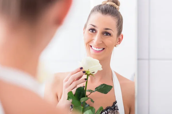 Женщина, держащая белая роза относительно себя в зеркале — стоковое фото
