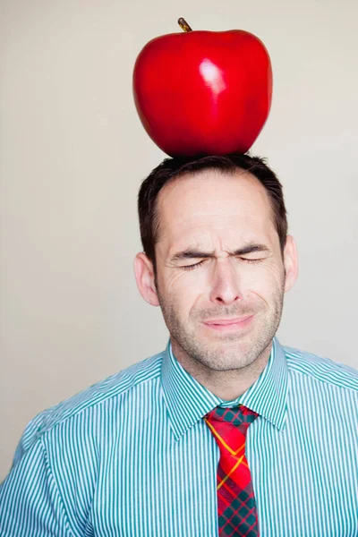 Человек с негабаритной apple на голове — стоковое фото