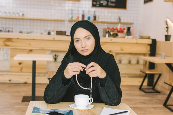 Мусульманская женщина, сидя в кафе — стоковое фото
