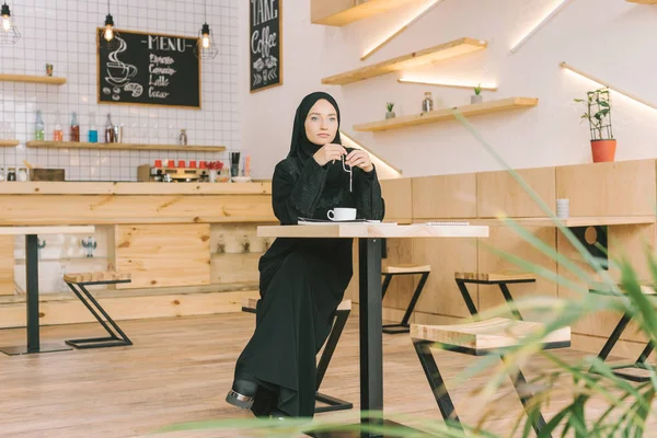Мусульманская женщина с четки в кафе — стоковое фото
