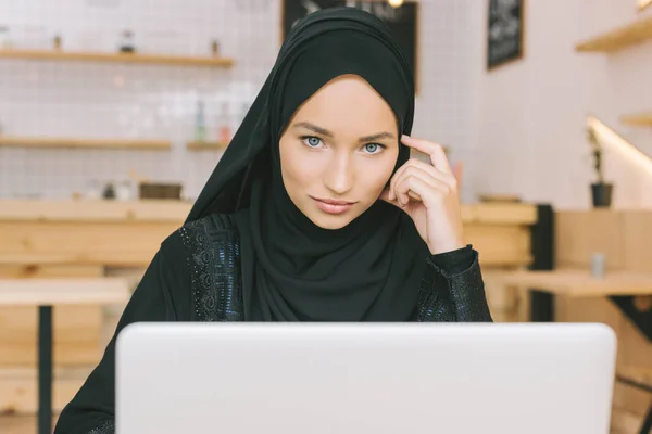 Мусульманская женщина, используя ноутбук в кафе — стоковое фото