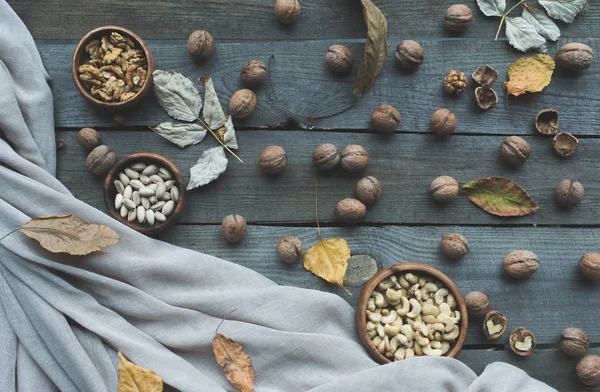 Ассорти из орехов и осенние листья — стоковое фото