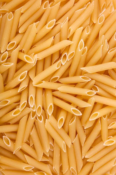 Close-up picture of macaroni texture use as background. Yellow dry pasta and spaghetti textures background for Italian food ingredient. Organic yellow rigate pasta. — стоковое фото