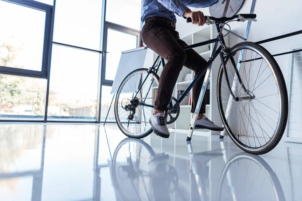 Бизнесмен с велосипедов в офисе — стоковое фото